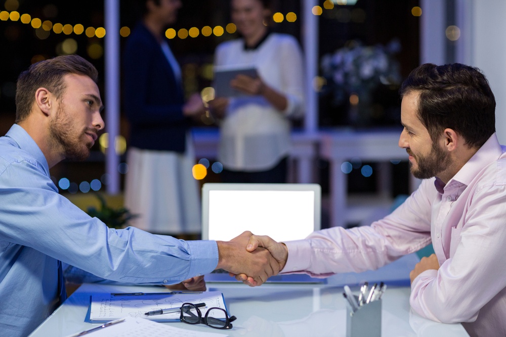 Businessmen shaking hands in conference room at office