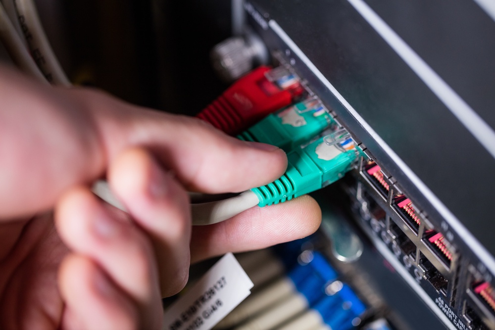 Close-Up of technician plugging ethernet in a rack mounted server in server room-2